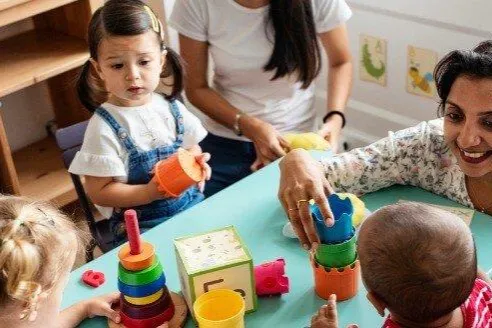 nursery-children-playing-with-teacher-in-the-classroom-picture-id1125881964-1.jpg