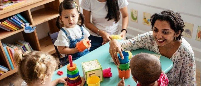 nursery-children-playing-with-teacher-in-the-classroom-picture-id1125881964-1.jpg